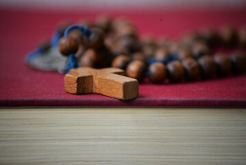 Holly Bible and wooden rosary religious background