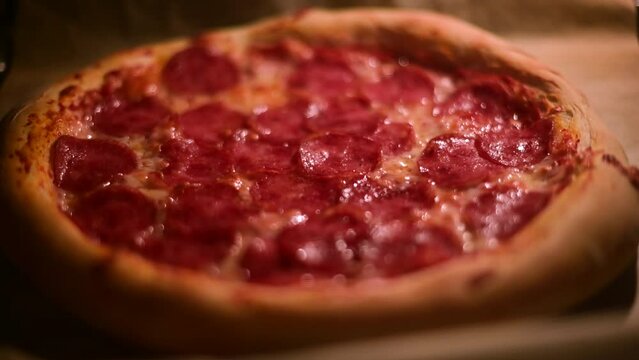 Italian pizza pepperoni is cooked in a home electric oven. Pizza with salami in hot oven close up. Food video. UHD 4k video