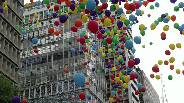 Balloons fly over city buildings