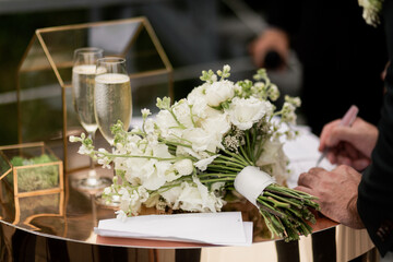 a glass of champagne on the registration table and a wedding bouquet