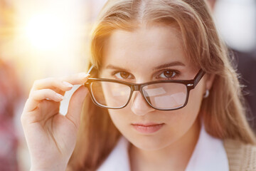 Attractive office worker writing in notepad placed on bright desktop