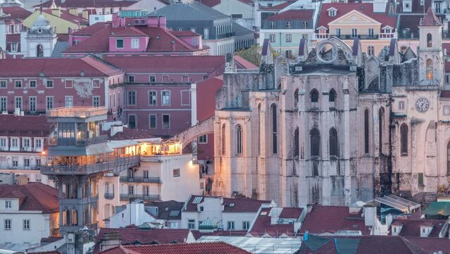 Santa Justa Lift day to night timelapse, also called Carmo Lift and Convento da Ordem do Carmo, historical church. View from above after sunset. Lisbon from above: Barrio Alto district. Portugal