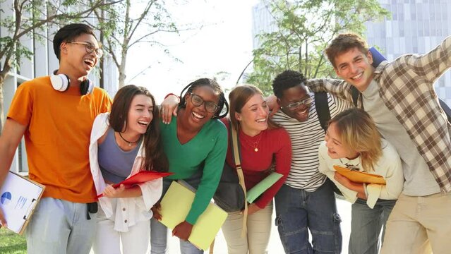 Big group of real students smiling and looking at camera together at high school. Happy teenagers laughing at university campus. Multiracial classmates standing outside. Best friends having fun