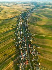 Suloszowa village among farm cultivated fields at sunset, aerial countryside view of Krakow County, Poland
