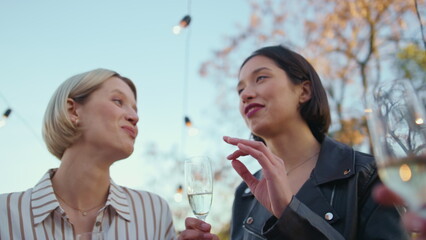 Happy woman saying toast at birthday party closeup. Friends cheering champagne