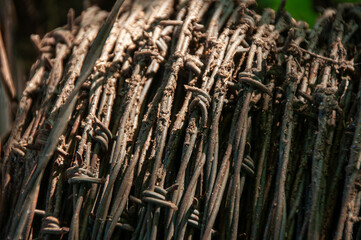 A close-up of old rusty Barbed Wire rolled up in a spool