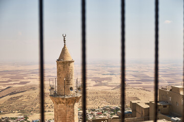 View of Grand Mosque of Mardin minaret, city roofs and Mesopotamian plain. South-eastern part of Turkey. 