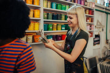 Smiling printing shop workers choosing paint buckets with color swatch