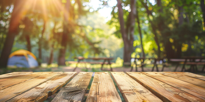 Empty wooden table with camping background, tents and picnic tables blurred. Space to place product, advertising or brand