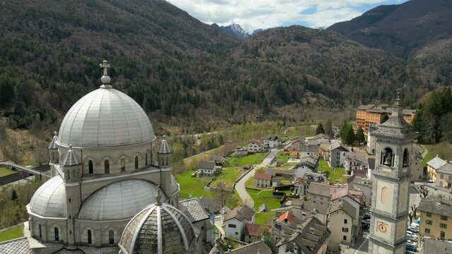 Great view on old swiss village center with beautiful cathedral surrounded by houses located in the foot on mountains, Switzerland, Europe. High quality 4k footage