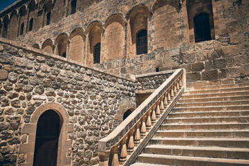 Balustrades and stairs carved out of stone. Stone stairway in courtyard of Deyrulzafaran monastery,...