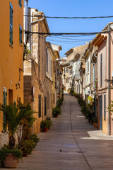 Carrer de la Roca, a narrow street lined with plant pots, in Alcudia old town, Mallorca, Spain, Balearic Islands