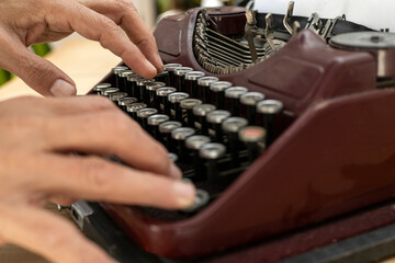 Man's hands typing on antique typewriter