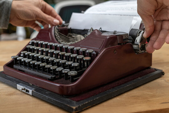 Man's hands typing on antique typewriter