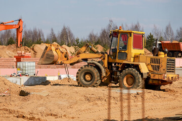 amazing photo of a loader against the backdrop of a construction site in sunny weather