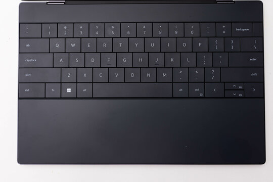 Close-up of a sleek, contemporary modern black laptop keyboard with chiclet keys, featuring a minimalist and portable design, perfect for productivity and work tool in the office