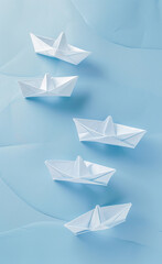 A series of paper boats arranged on a light blue-AI generated image 
 - obrazy, fototapety, plakaty
