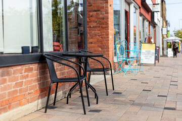 Small table and two chairs outdoors. Street cafe