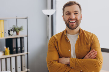 Portrait of a modern businessman man in a yellow shirt smiling with healthy teeth in the office - obrazy, fototapety, plakaty