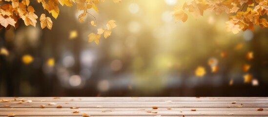 Colorful autumn leaves are gently falling from a tree onto a rustic wooden table, creating a cozy seasonal ambiance.