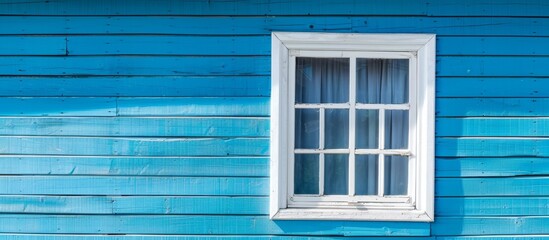 A blue house with a white window and a curtain