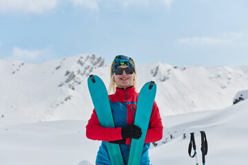 A professional woman skier rejoices after successfully climbing the snowy peaks of the Alps