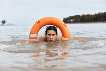 Summer Safety: An Alert Lifeguard Rescuing in Blue Waters, Asian Lifesaver on Guard Duty at the...