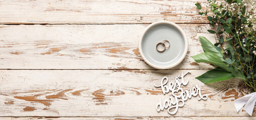Tray with wedding rings, bouquet of flowers and text BEST DAY EVER on white wooden background