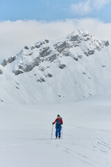 A Female Mountaineer Ascends the Alps with Backcountry Gear - 776513883