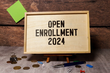 Concept of Open Enrollment 2024 write on sticky notes isolated on Wooden Table