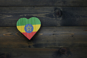 wooden heart with national flag of ethiopia on the wooden background.