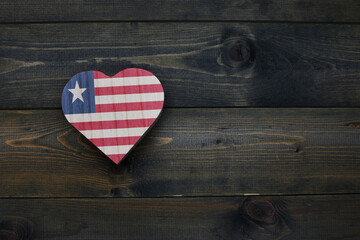 wooden heart with national flag of liberia on the wooden background.