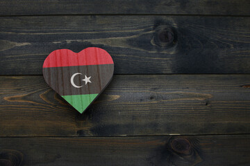 wooden heart with national flag of libya on the wooden background. - obrazy, fototapety, plakaty