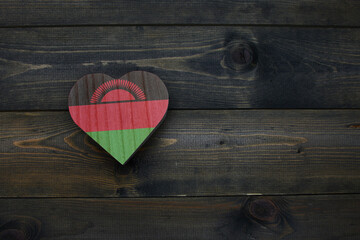 wooden heart with national flag of malawi on the wooden background.