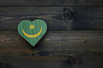 wooden heart with national flag of mauritania on the wooden background.