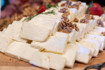 Board with different types of cheese: Dor blu, chedar, Parmesan, brie, honey sauce, finger bread and strawberry. Restaurant menu plate. cheese platter.
