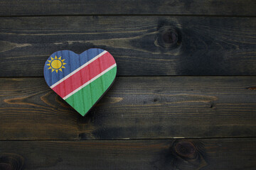 wooden heart with national flag of namibia on the wooden background.