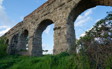 Fototapeta na wymiar Ruins of the ancient Acqua Claudia aqueduct at Parco degli Acquedotti, Rome, Italy