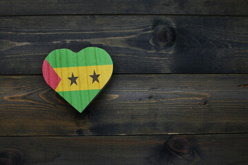 wooden heart with national flag of sao tome and principe on the wooden background.