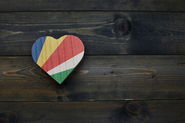 wooden heart with national flag of seychelles on the wooden background.