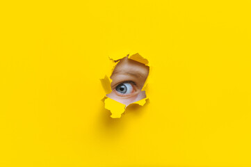 The right eye looks into a hole in the yellow paper. The child watches his parents. A curious look....