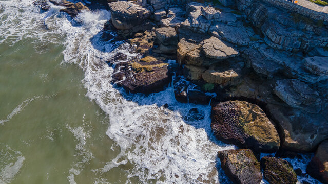 Hermosas fotos aerea tomadas con drone de olas chocando con rocas rompeolas de la ciudad de Mar del Plata, Argentina.