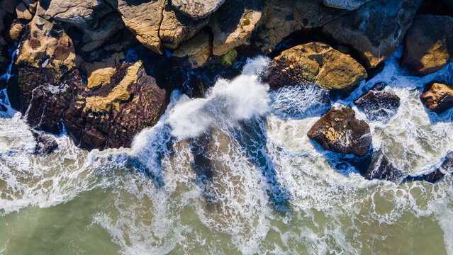 Hermosa foto aerea de olas chocando con rocas rompeolas de la ciudad de Mar del Plata, Argentina.
