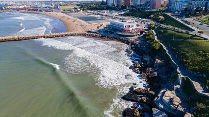 Hermosas fotos aerea tomadas con drone de olas chocando con rocas rompeolas de la ciudad de Mar del...