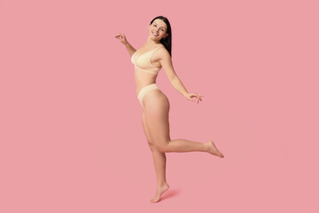 Body positive young woman in underwear smiling on pink background - obrazy, fototapety, plakaty