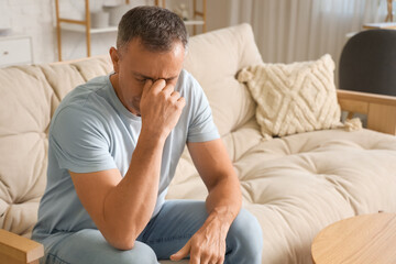 Mature man suffering from migraine at home