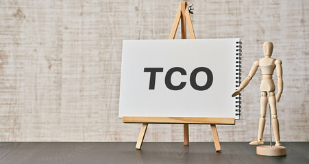 There is notebook with the word TCO. It is an abbreviation for Total Cost of Ownership as eye-catching image. - obrazy, fototapety, plakaty