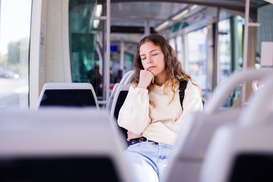 Portrait of a young woman passenger sleeping during her tram ride