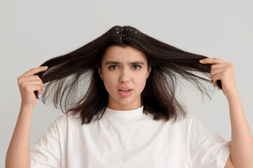 Young woman with dandruff problem on white background