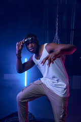 Fashion muscular rapper standing in neon lights of cool nightclub - 776567067